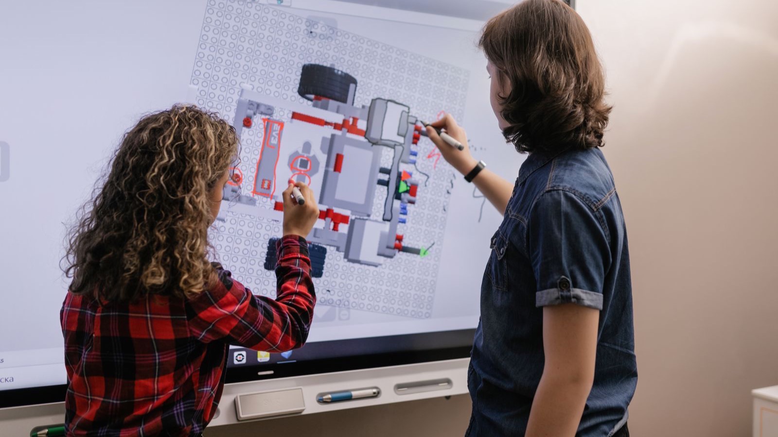 Zwei Lernende arbeiten an einem interaktiven Smartboard im Klassenzimmer, digitale Schulausstattung wie sie der Digitalpakt 2.0 fördert